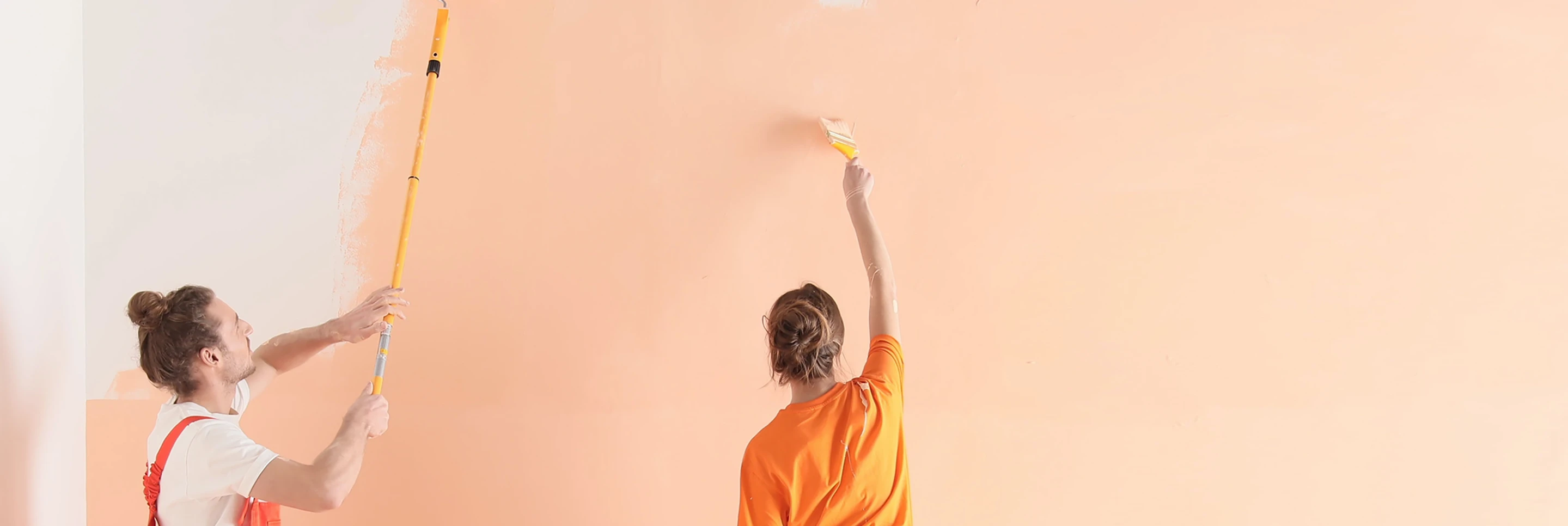 two people painting a wall